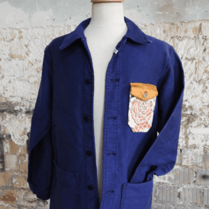 Veste de travail customisée avec empiècements de tissu et broderie main dans une démarche d'upcycling