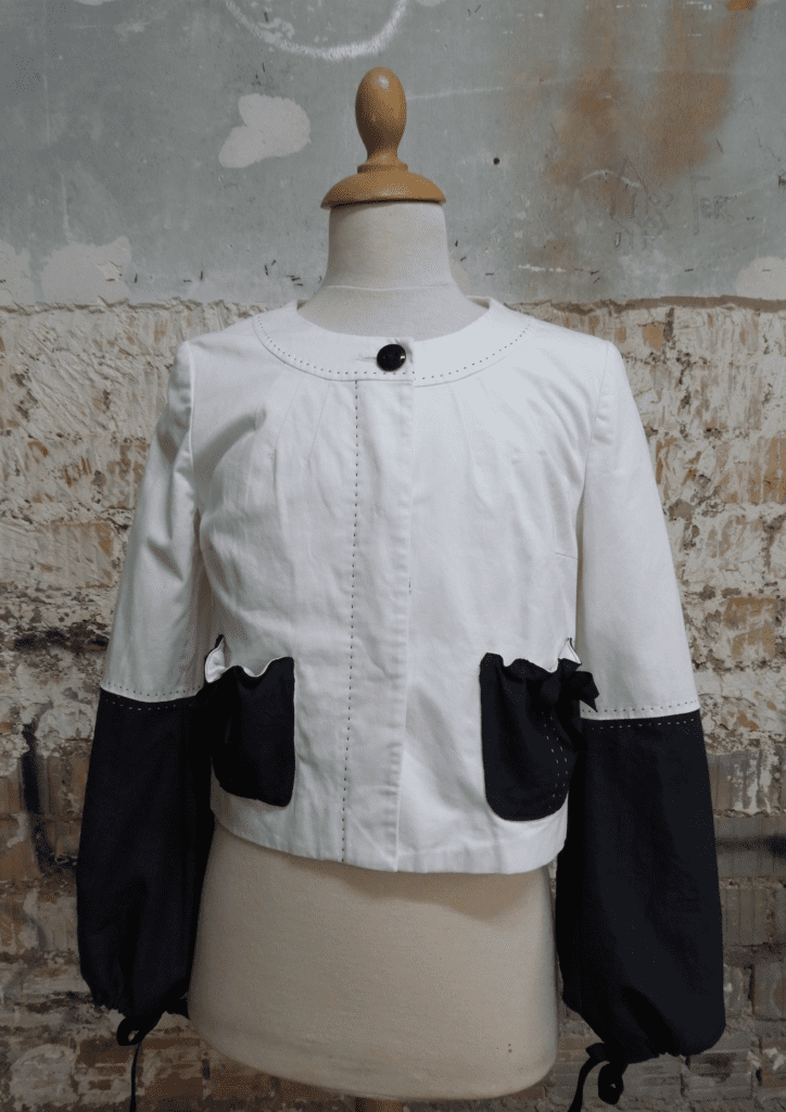 Veste blanche customisée avec broderie en empiècement de tissu dans une démarche d'upcycling